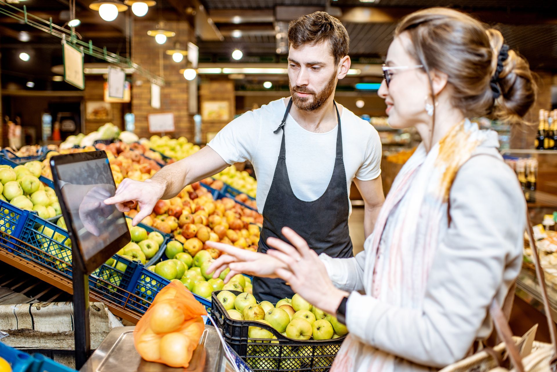 Un homme et une femme devant une balance de supermarché