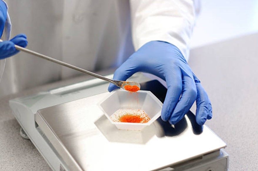 Une personne mesure une substance orange