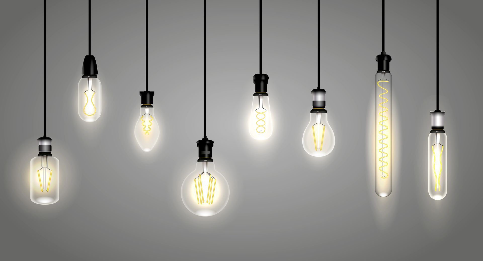 Huit ampoules de style Edison, de couleurs différentes, sont suspendues par des fils.