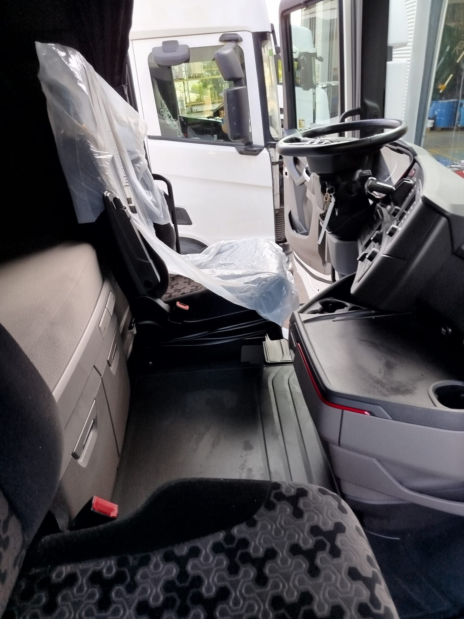 El interior de un camión con los asientos envueltos en plástico.