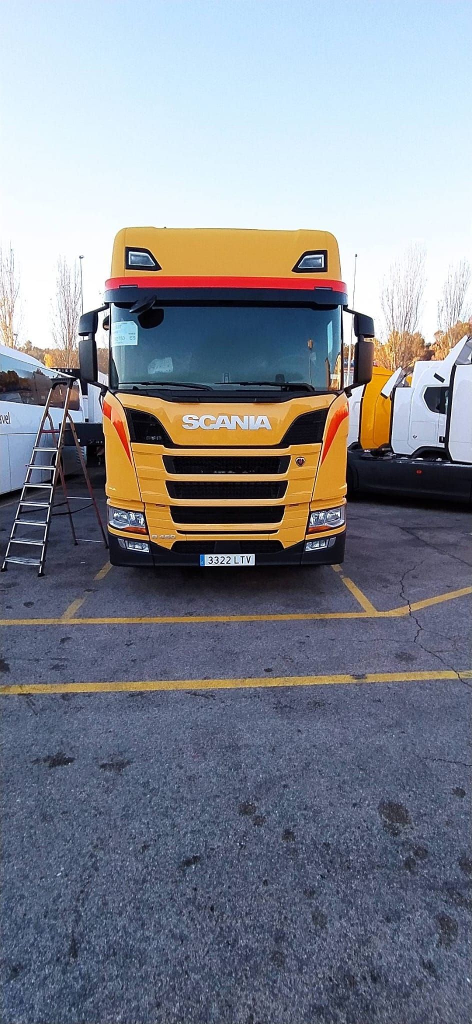 Un camión amarillo está estacionado en un estacionamiento.