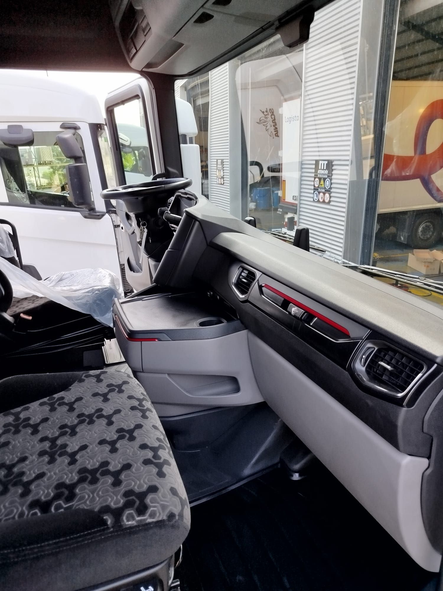 El interior de un camión con volante y tablero.