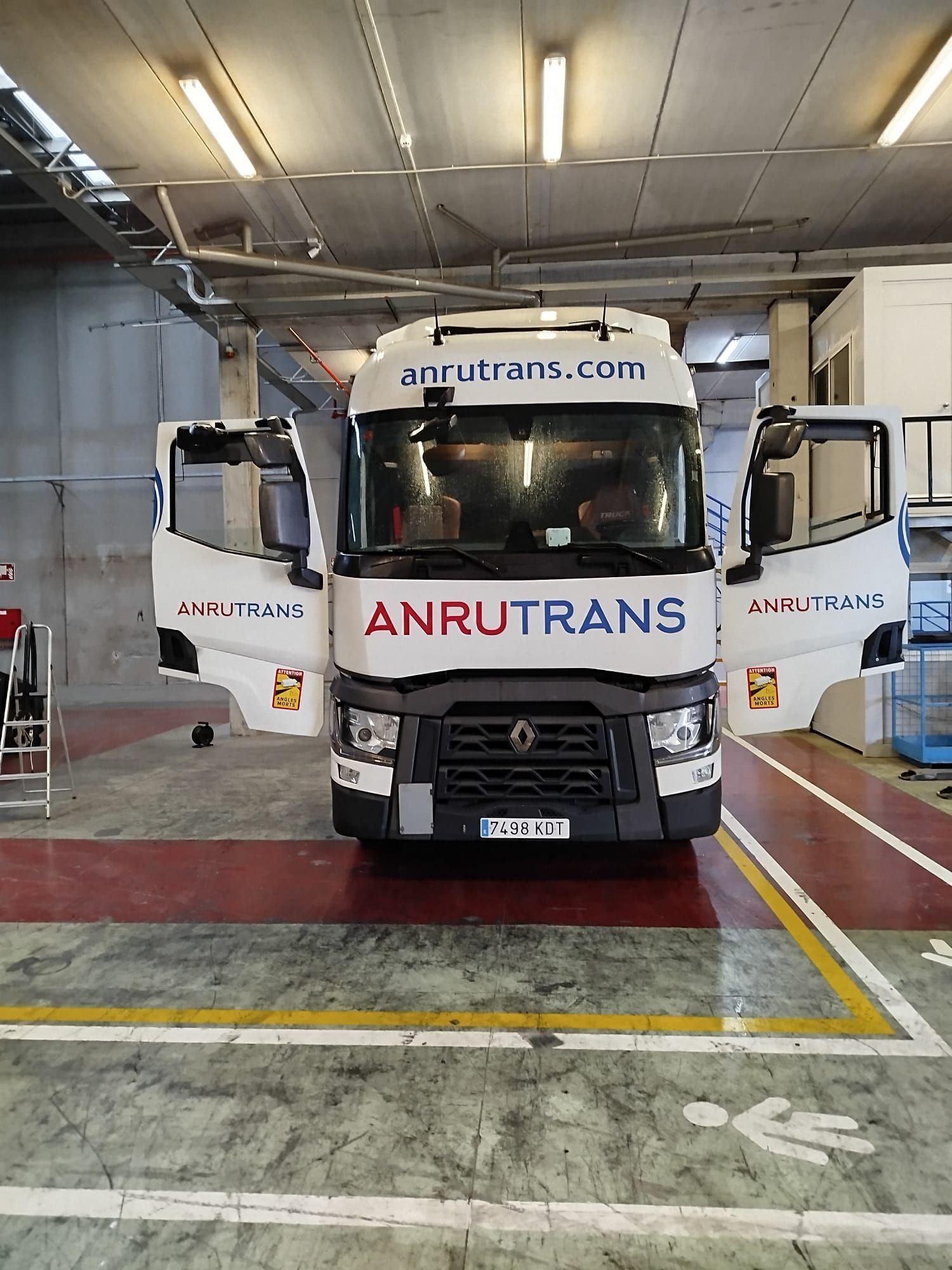 Un camión de Anrutrans está estacionado en un estacionamiento.