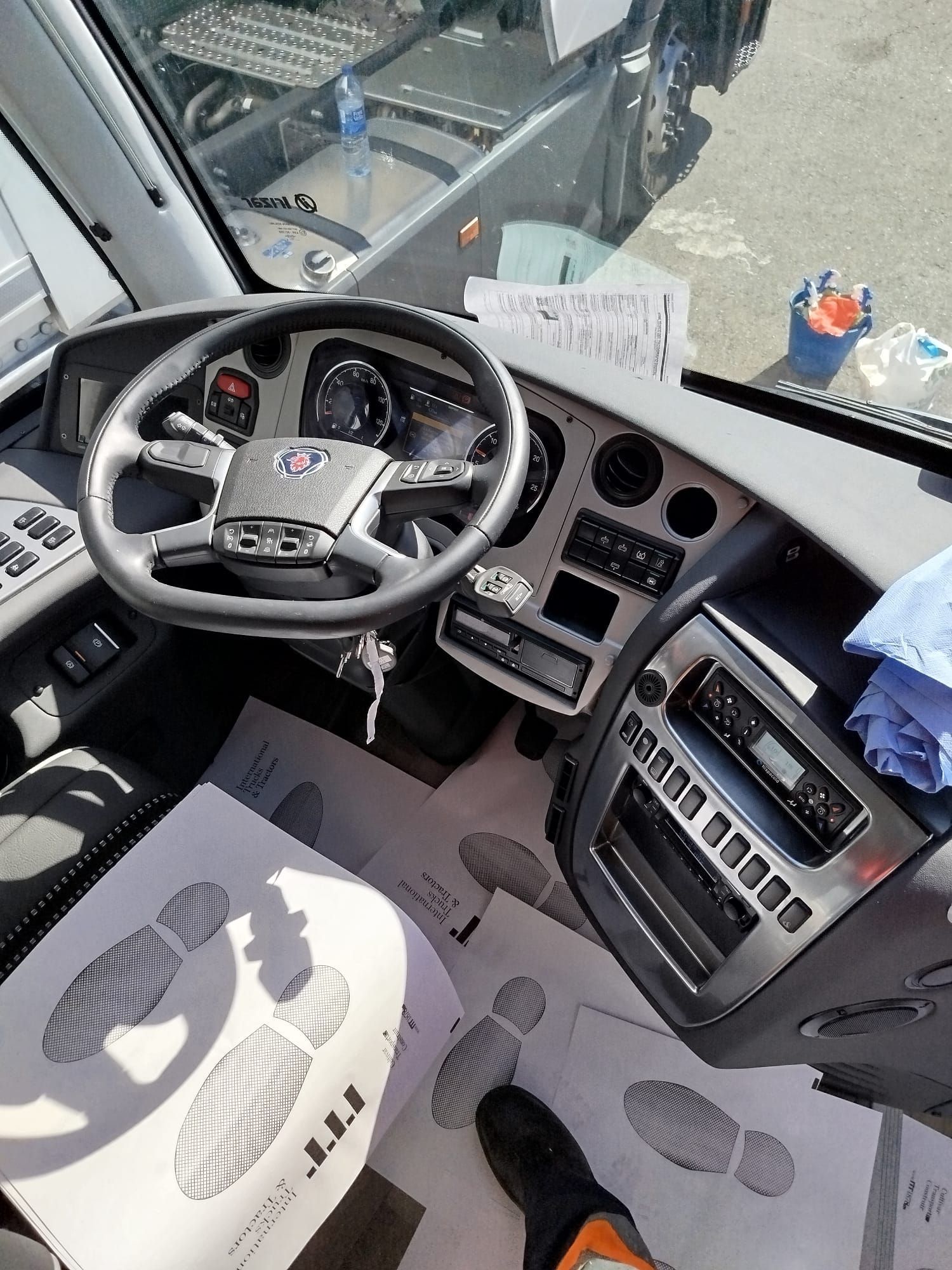 El interior de un autobús con volante y tablero.