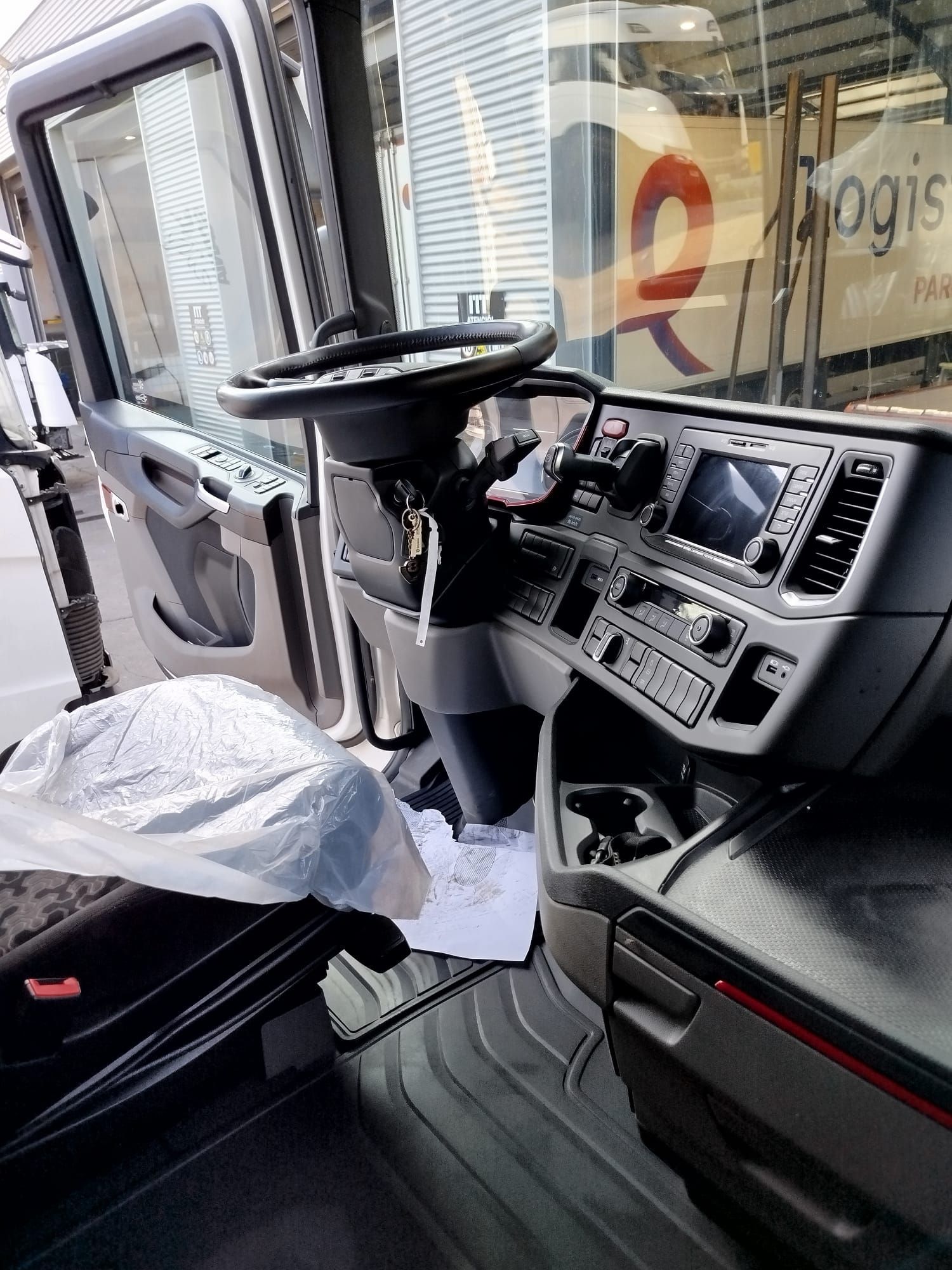 El interior de un camión con volante y tablero.