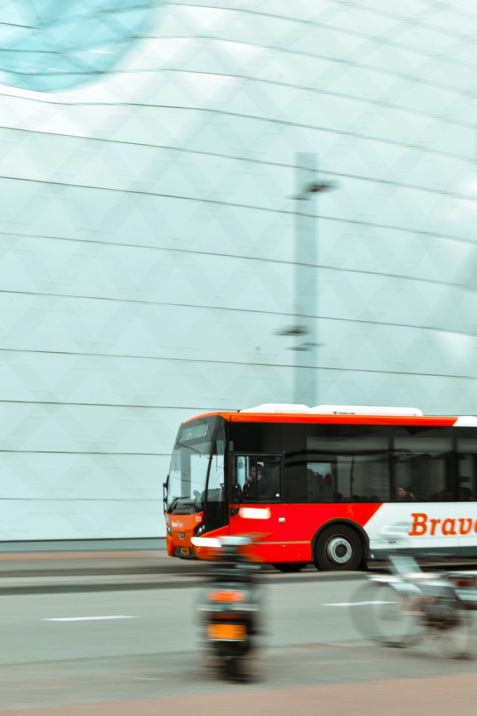 Un autobús rojo y blanco circula por una calle.