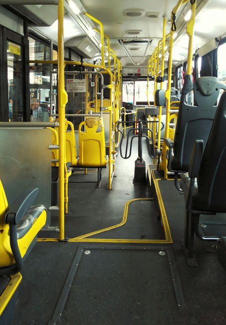El interior de un autobús vacío con asientos amarillos.