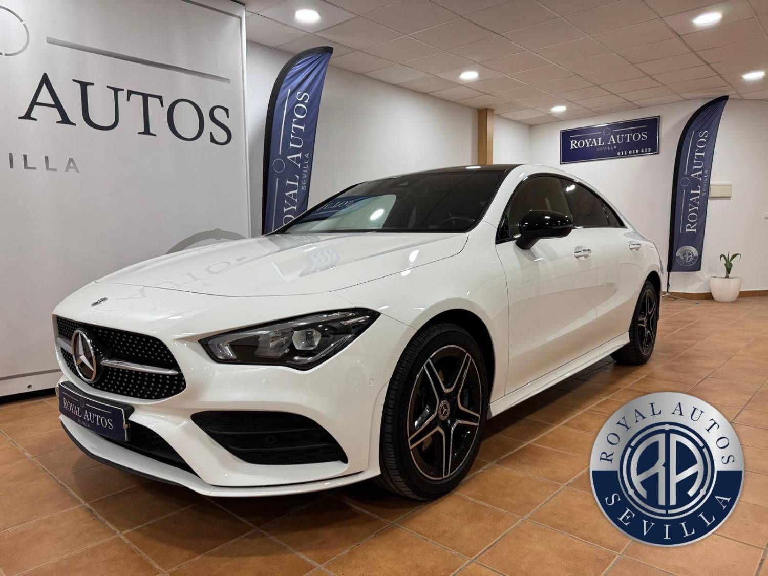 Mercedes-Benz CLA sedán de color blanco en una sala de exposición.