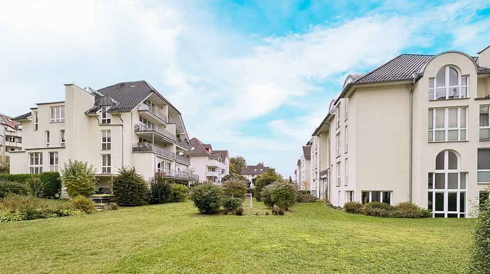 Ein weißes Haus mit einem Swimmingpool davor.