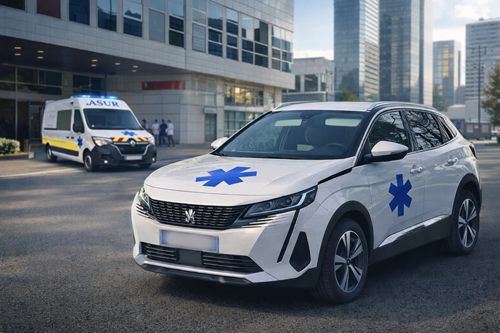 Fourgon-ambulance blanc garé devant un hôpital moderne, avec un véhicule d’urgence assorti en arrière-plan