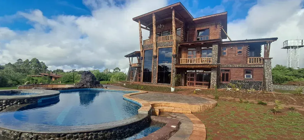 A large house with a swimming pool in front of it.