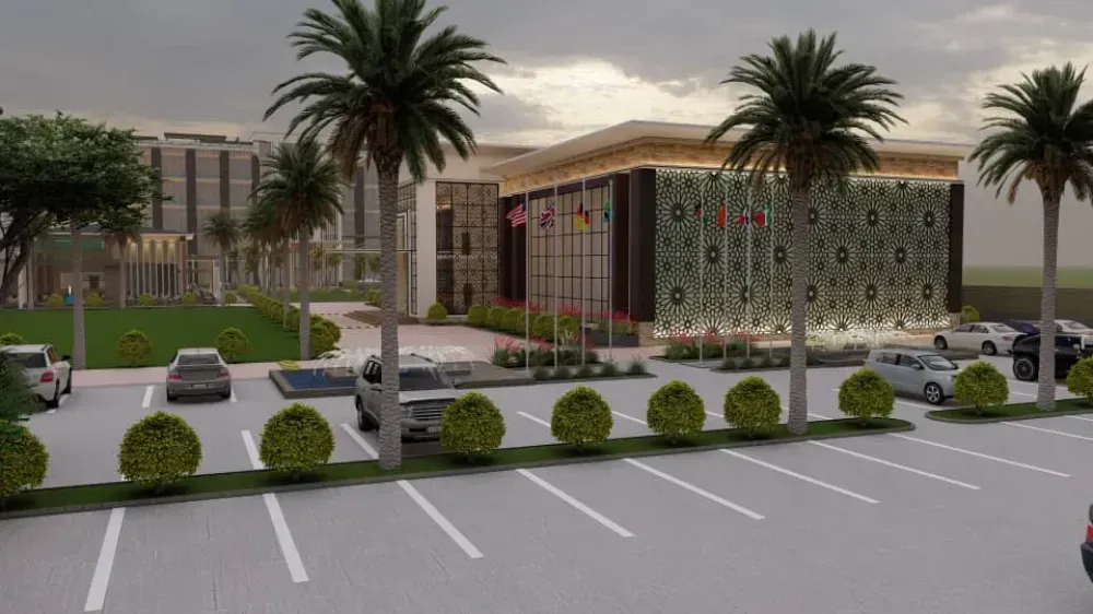 A parking lot with cars parked in front of a building with palm trees.