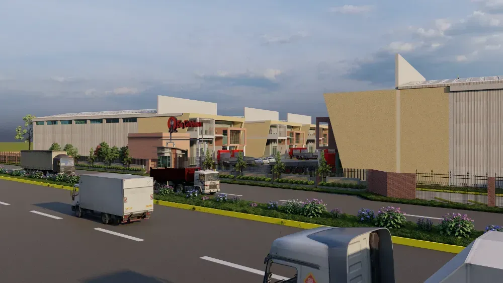 A group of trucks are driving down a road in front of a large building.