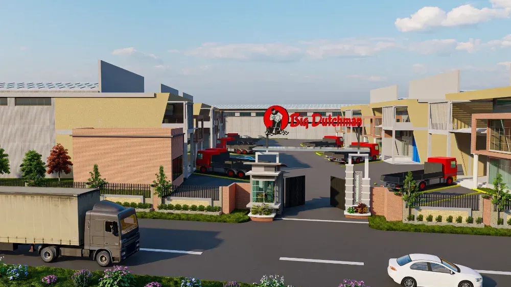 A truck and a car are driving down a street in front of a building.