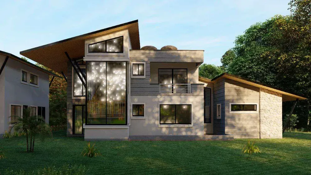 A modern house with a lot of windows is sitting on top of a lush green field.