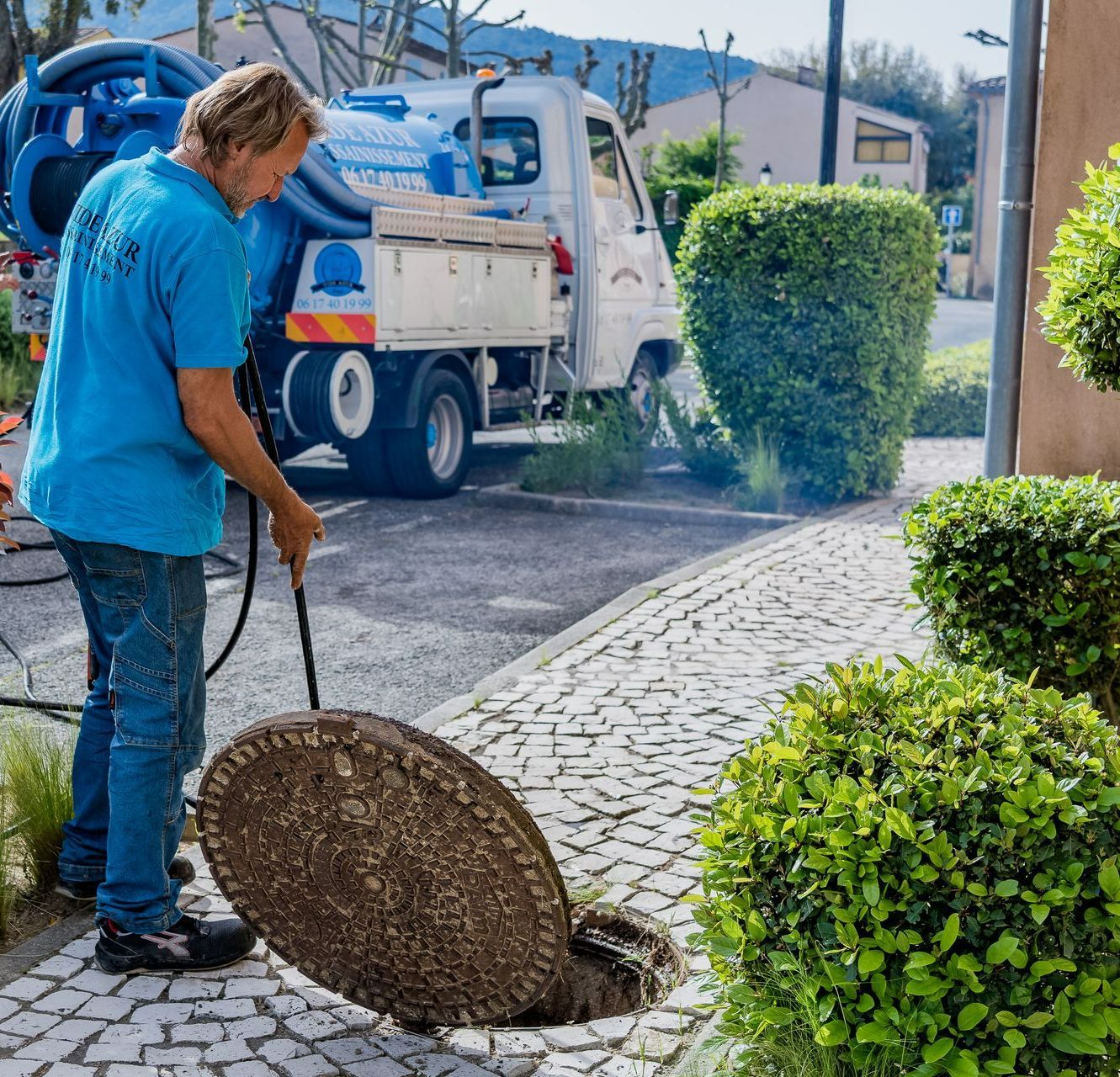 Personnel de l'entreprise dirigeant un jet haute pression dans une canalisation