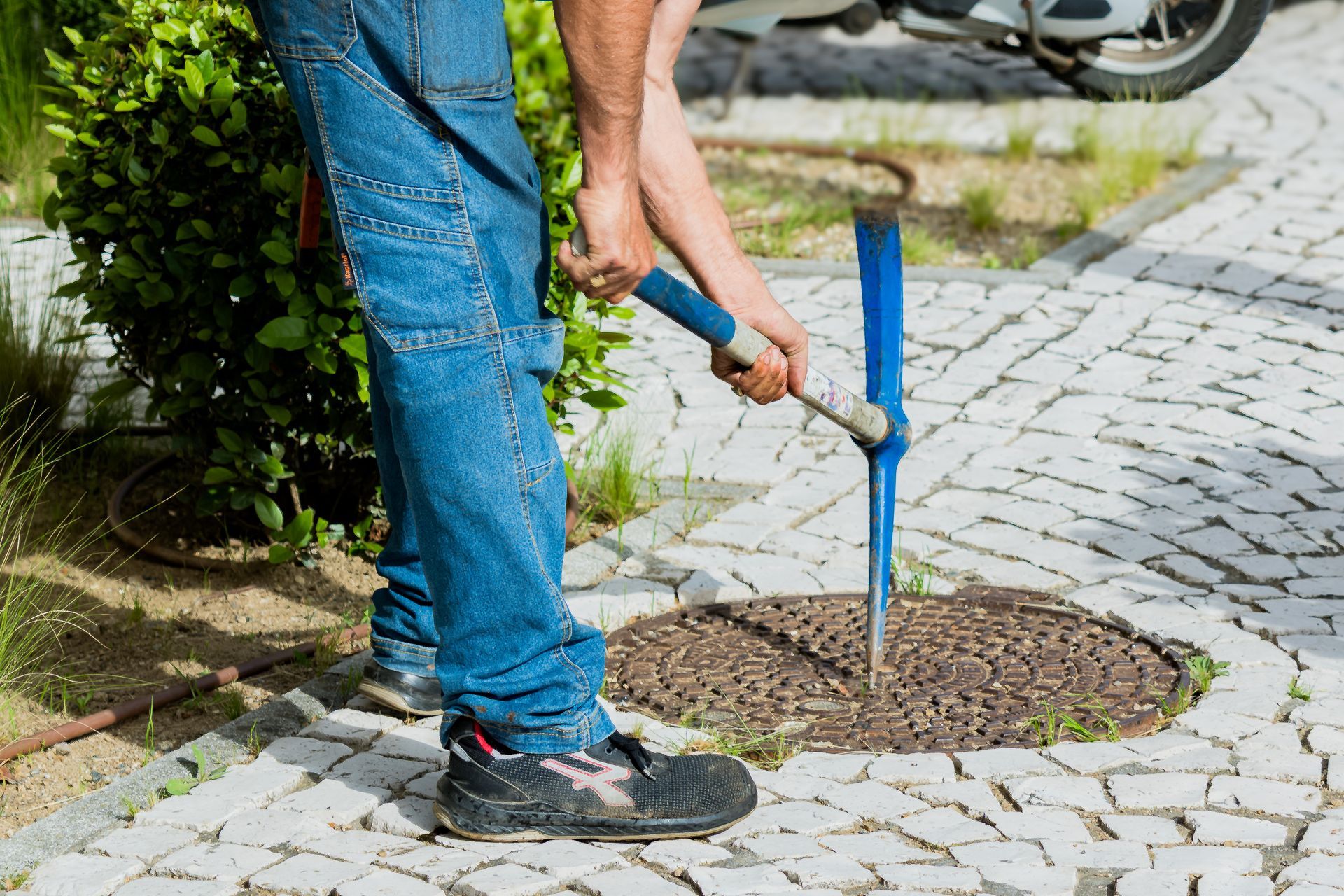 Ouverture d'une plaque de fosse septique à la pioche