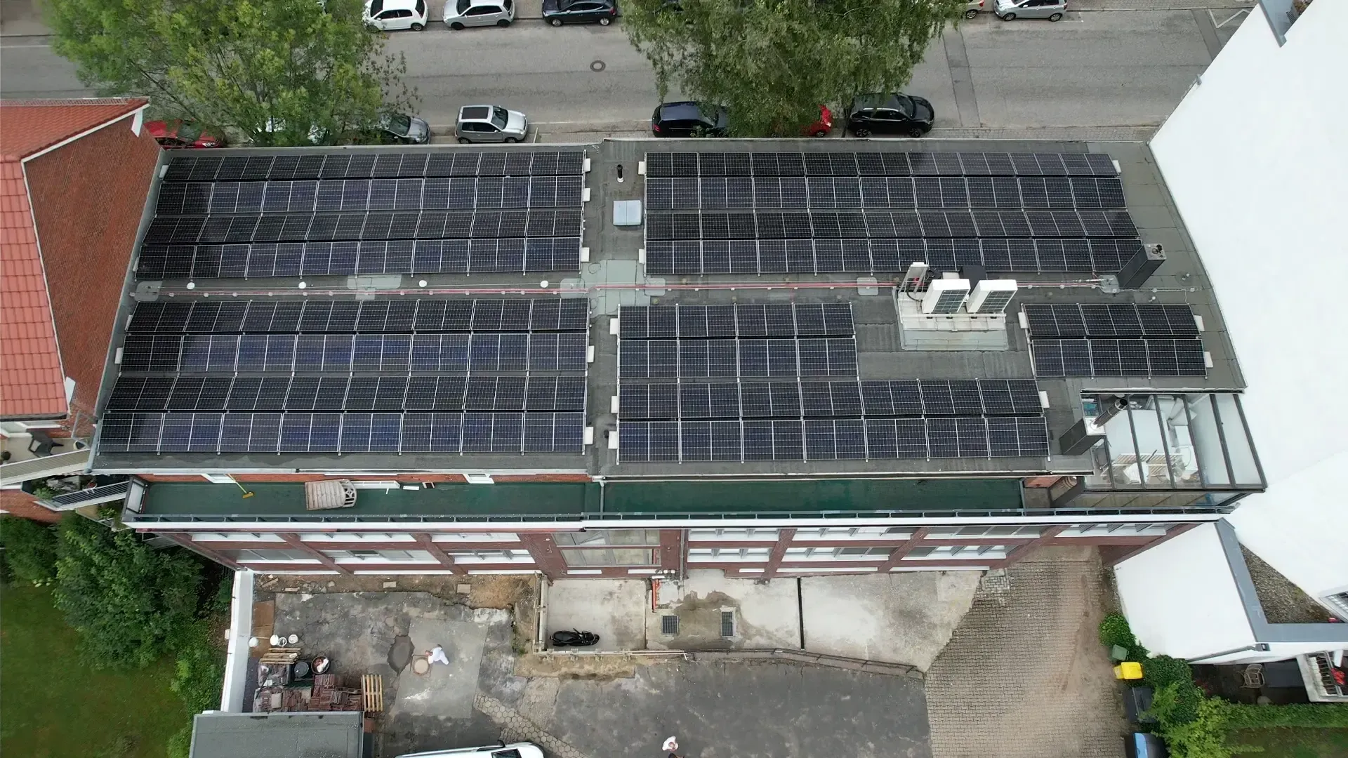Eine Luftaufnahme eines Gebäudes mit Solarmodulen auf dem Dach