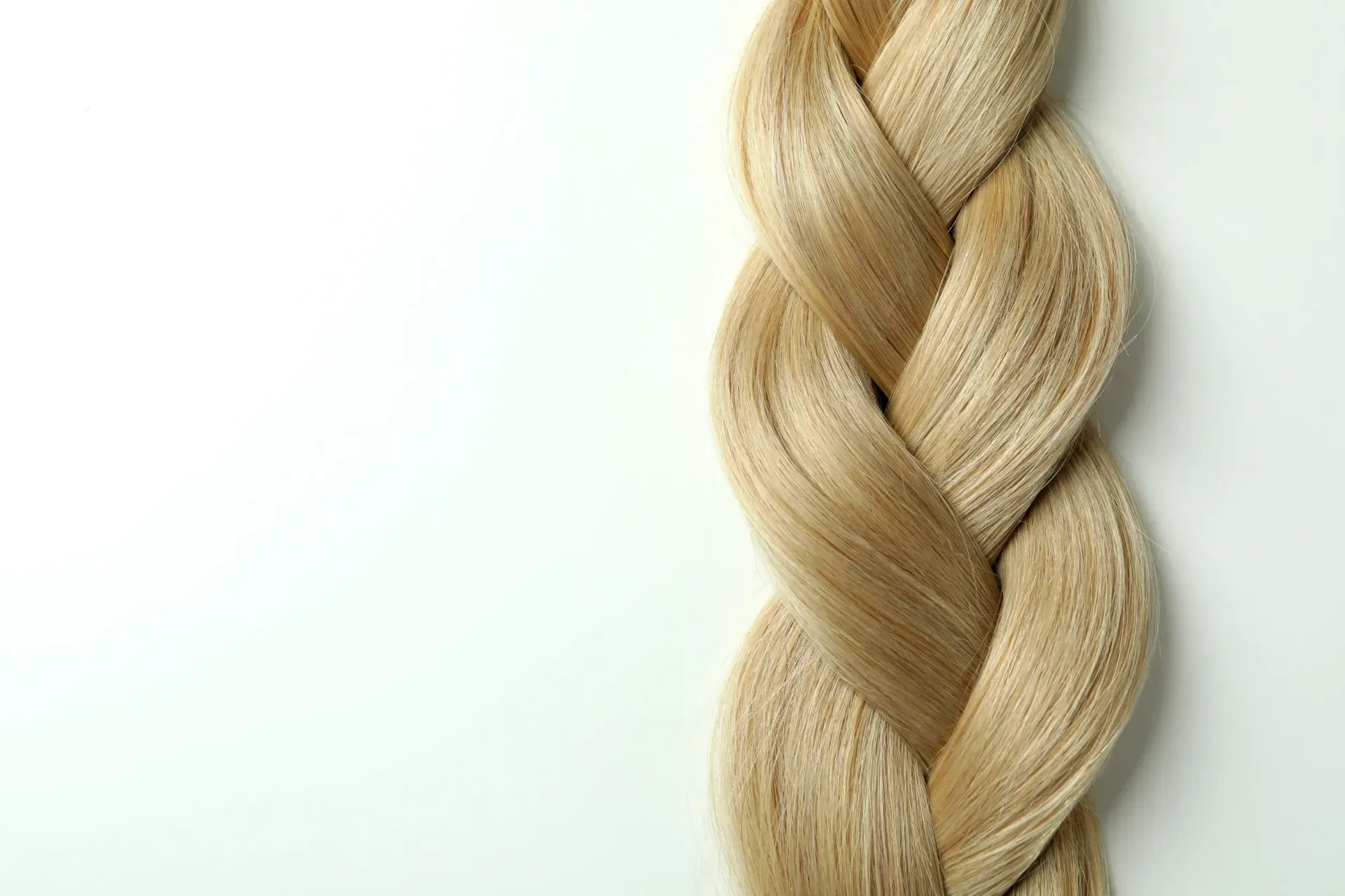 Un primer plano de un mechón de cabello trenzado sobre un fondo blanco.