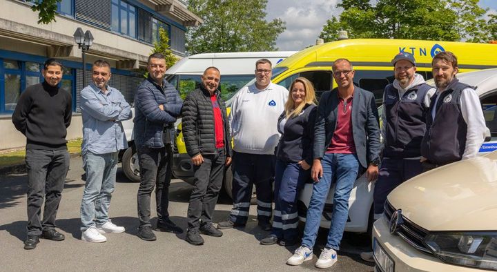 Am Straßenrand steht ein weißer Lieferwagen mit offener Tür.