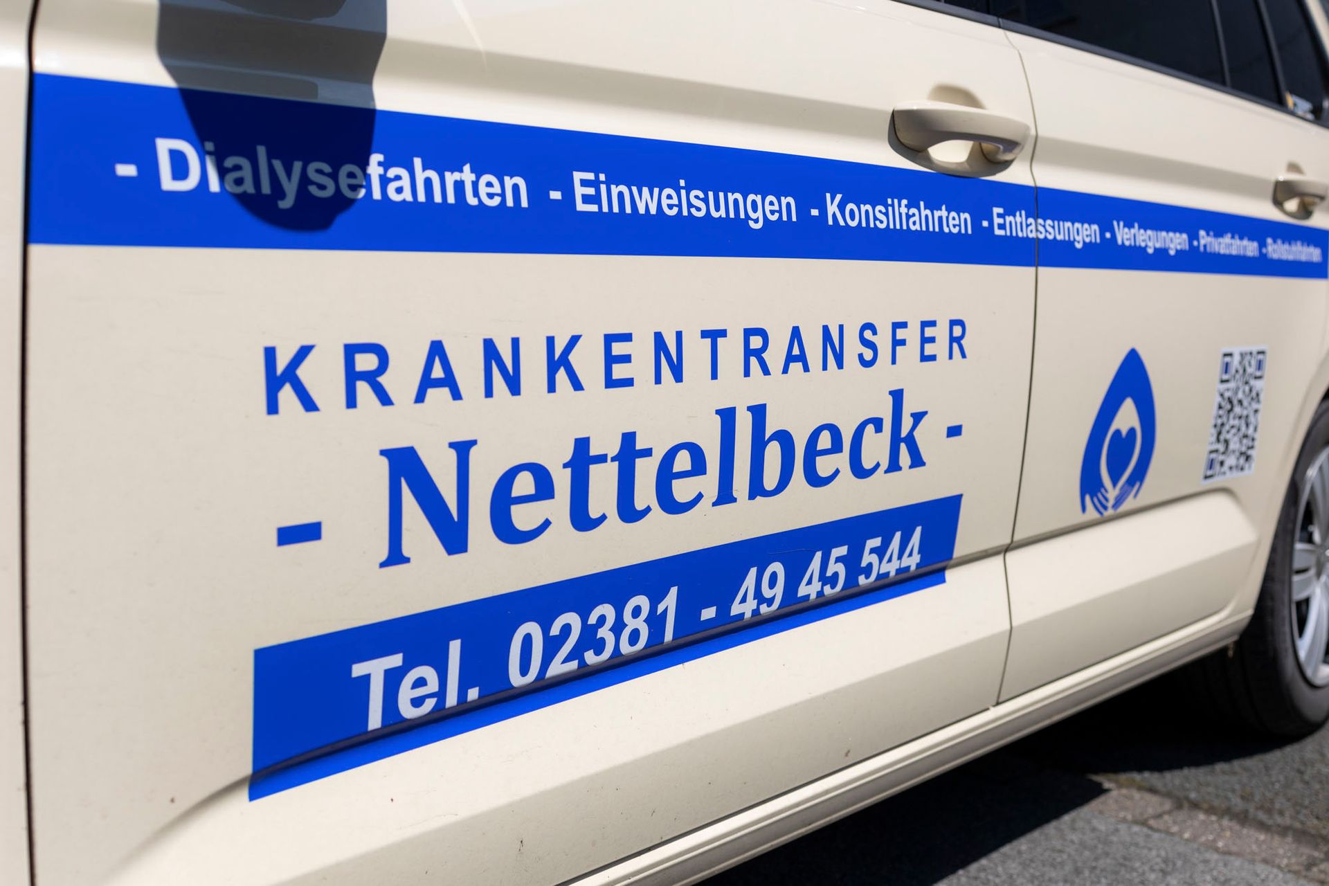 Am Straßenrand steht ein weißer Lieferwagen mit offener Tür.