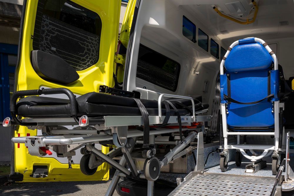 Ein Transportwagen mit einer Trage und einem Rollstuhl darin.