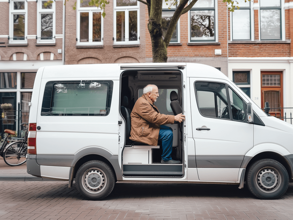 Ein älterer Mann sitzt hinten in einem weißen Lieferwagen.