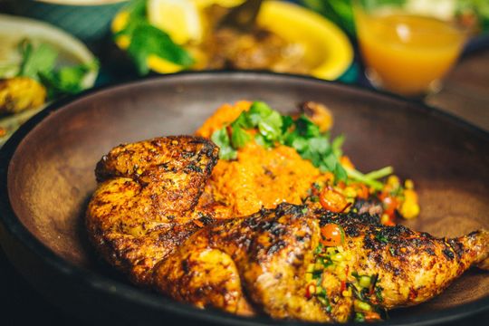 Une assiette en bois avec du poulet.