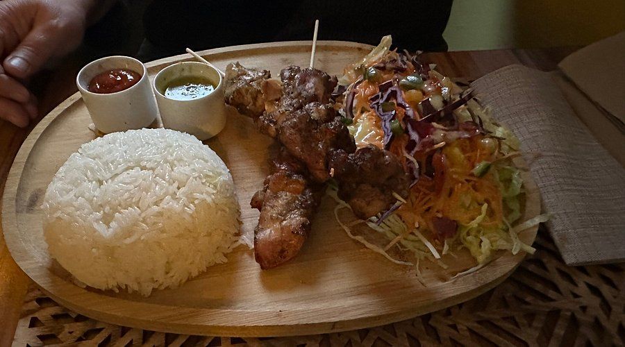 Un plat avec du riz et des brochettes.