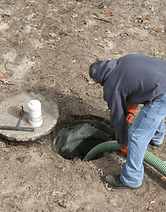 Homme qui vidange une fosse septique.