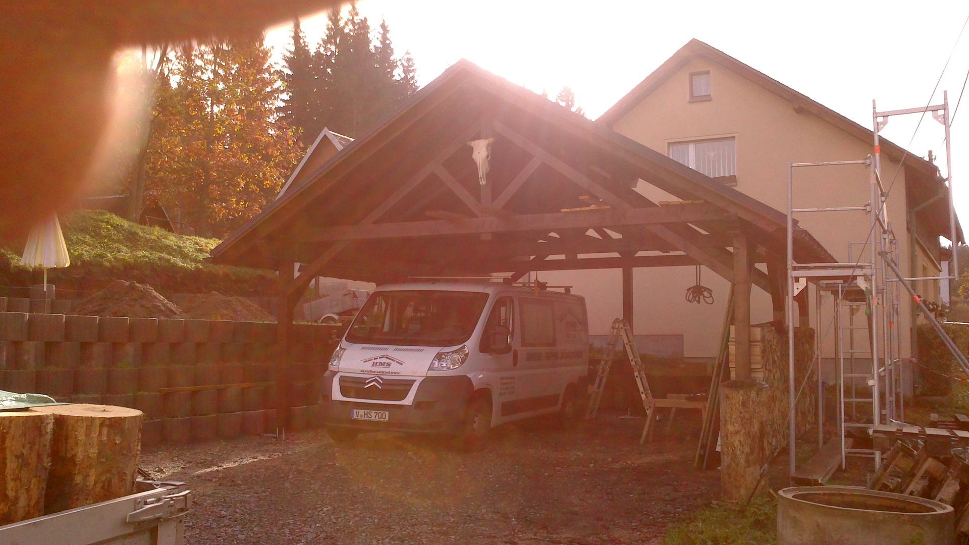 Haus im Bau mit Metallgerüst und teilweise abgedecktem Dach in einem Kieshof