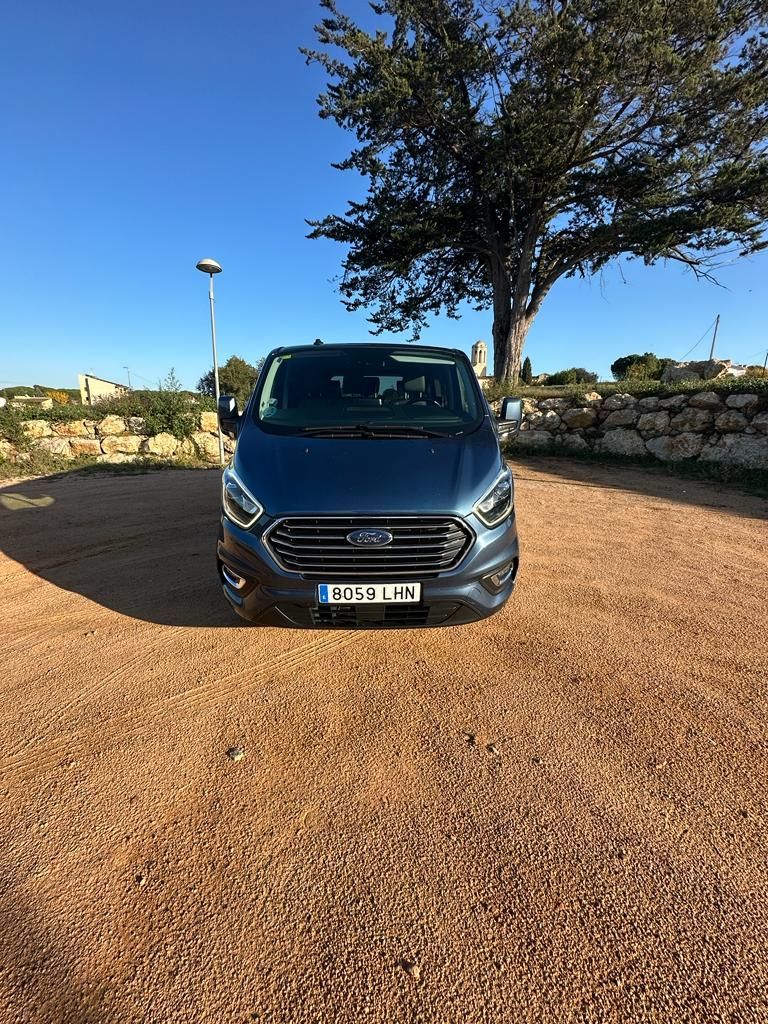 Una camioneta Ford está estacionada en un lote de grava con un árbol al fondo.