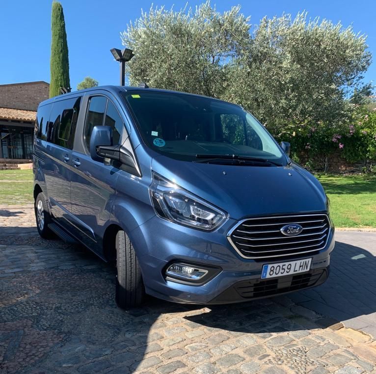 Una camioneta Ford azul está estacionada en una calle adoquinada