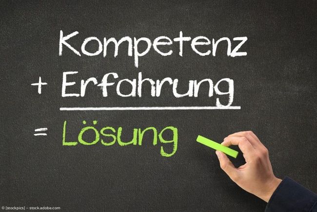 Blackboard with German text “Kompetenz + Erfahrung = Lösung,” a hand writing “Lösung” in green.