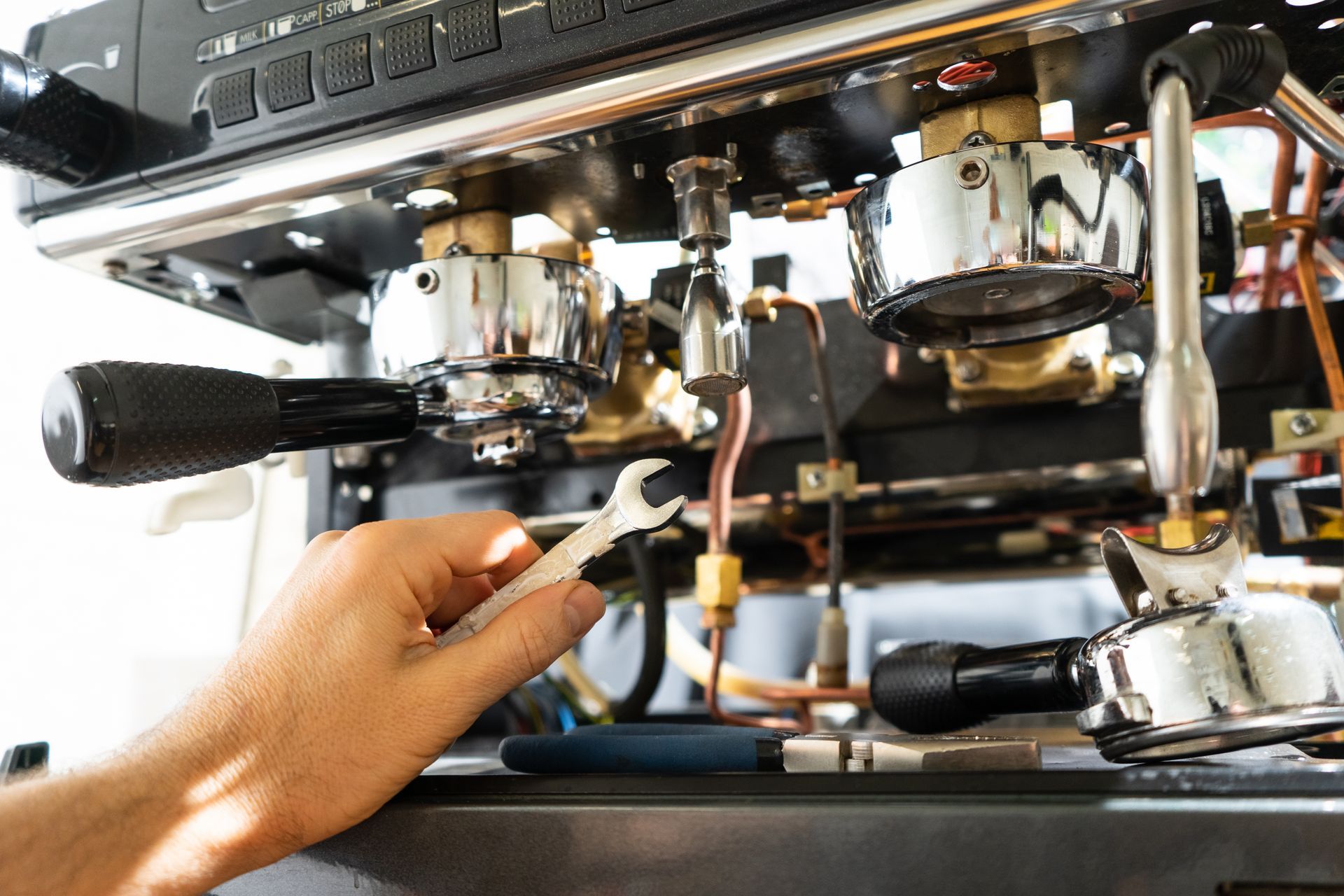Une personne réparant une machine à café.