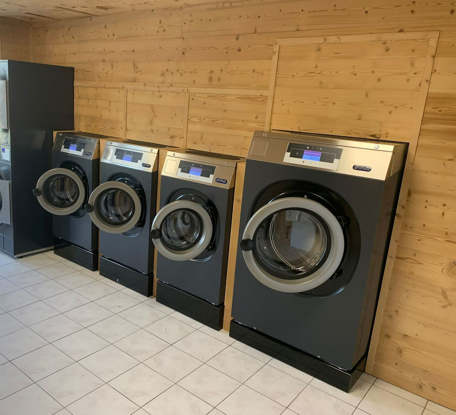 Des draps devant des machines à laver.