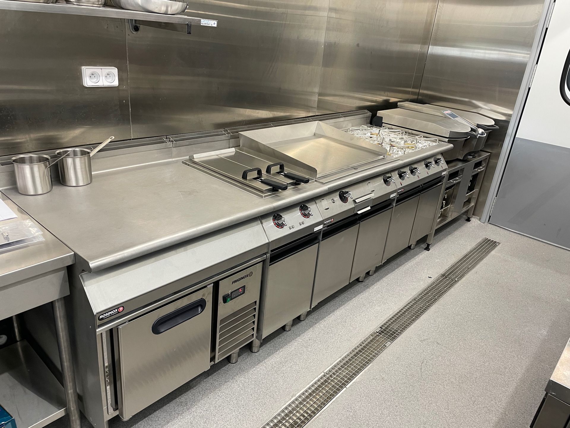 Une cuisine professionnelle avec une grande hotte.