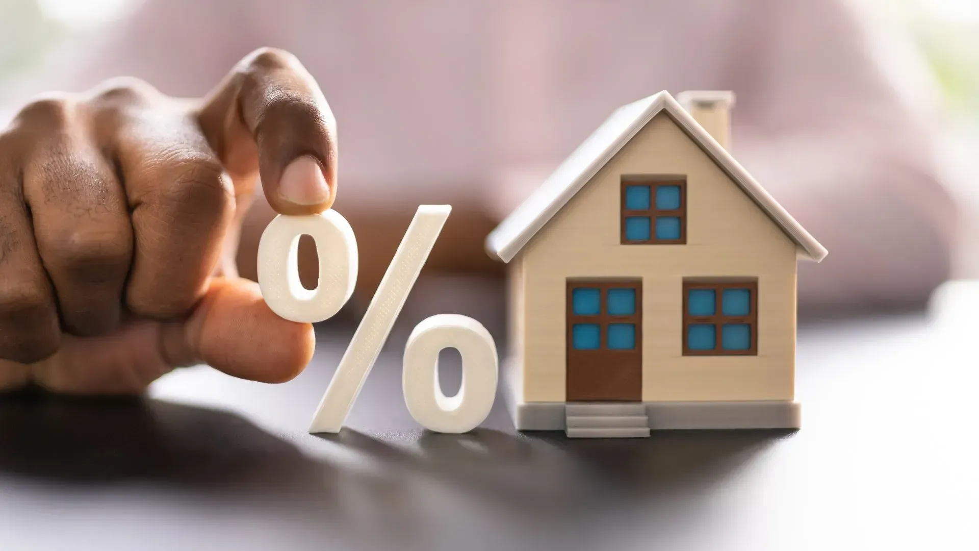 Persona con traje entregando llaves con amuleto de casa a otra persona.