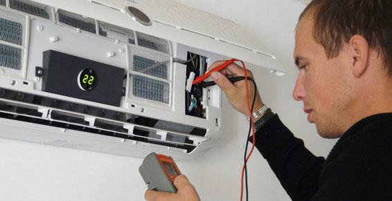 Technicien contrôlant le courant dans le climatiseur
