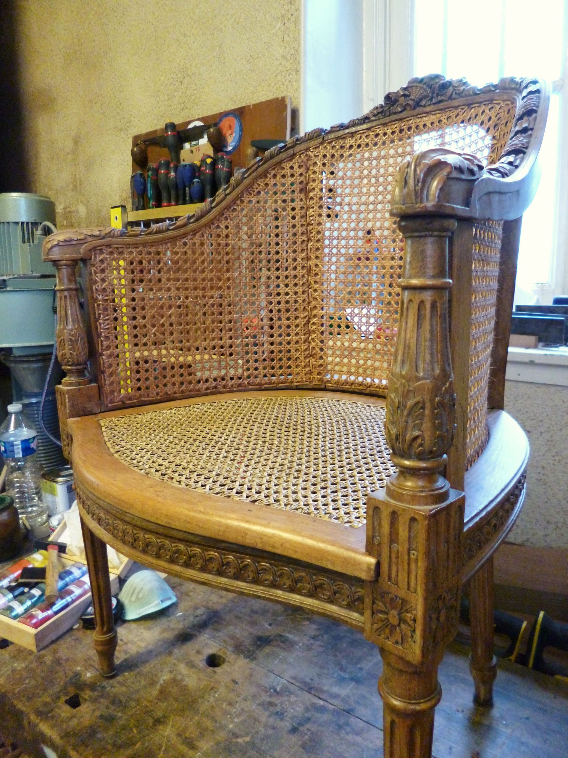 Deux fauteuils rembourrés dans un salon lumineux, avec une petite table et une fenêtre en arrière-plan.