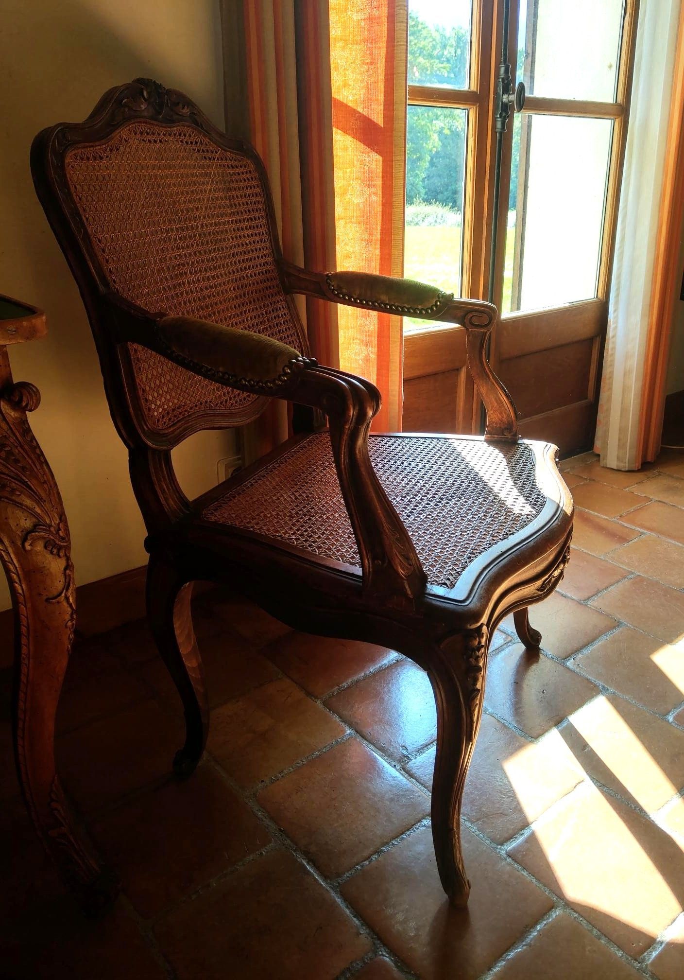 Fauteuil tissé près d'une fenêtre ensoleillée sur un sol en terre cuite