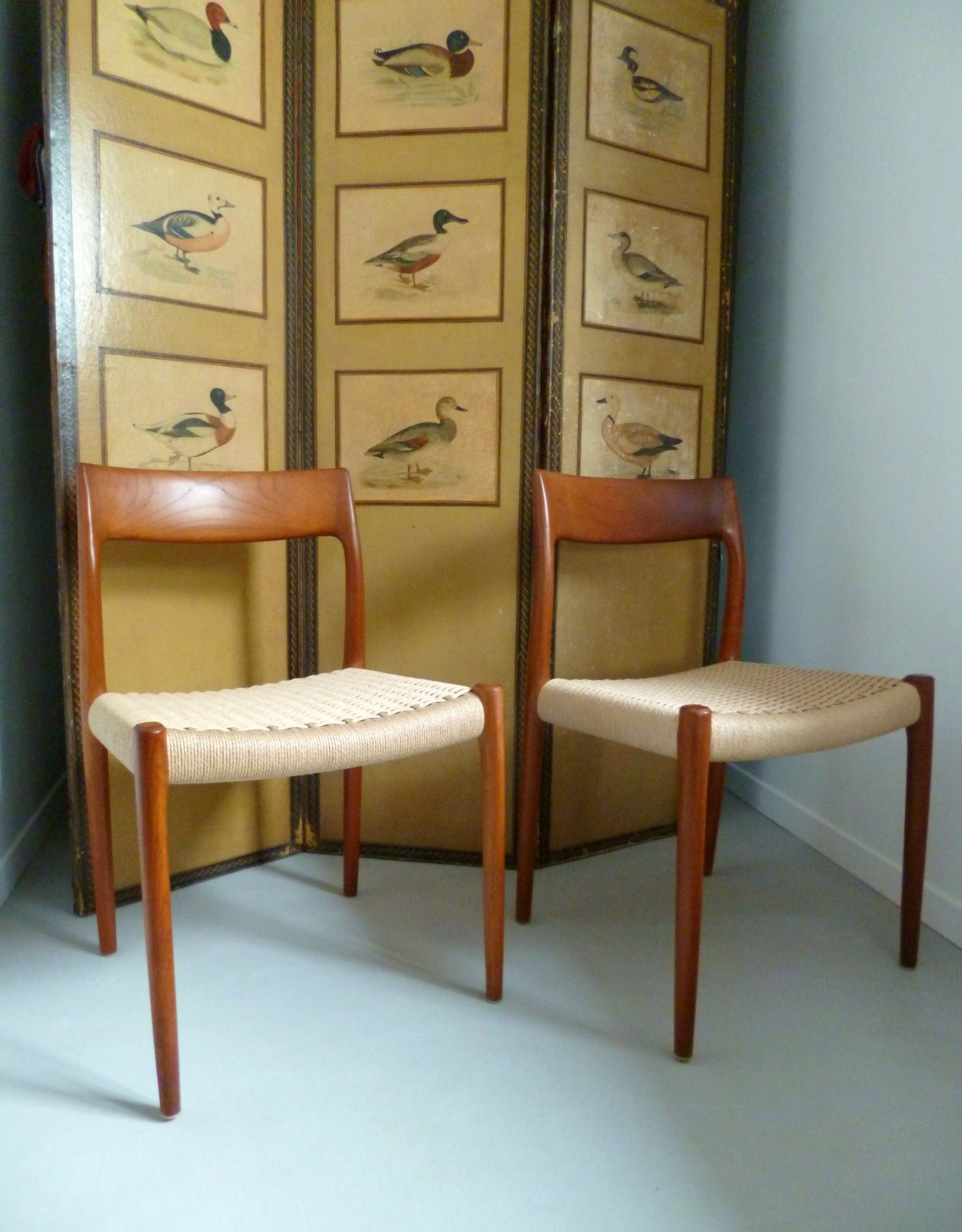 Chaise en bois ornée avec coussin et dossier à motifs dorés dans une salle d'exposition