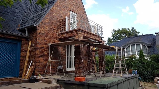 Ein Gerüst an einem begehbaren Vordach mit Stahlzaun