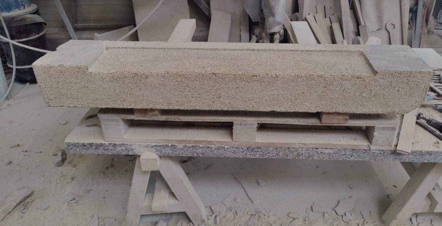 Long bloc de pierre rectangulaire sur un établi dans un atelier poussiéreux