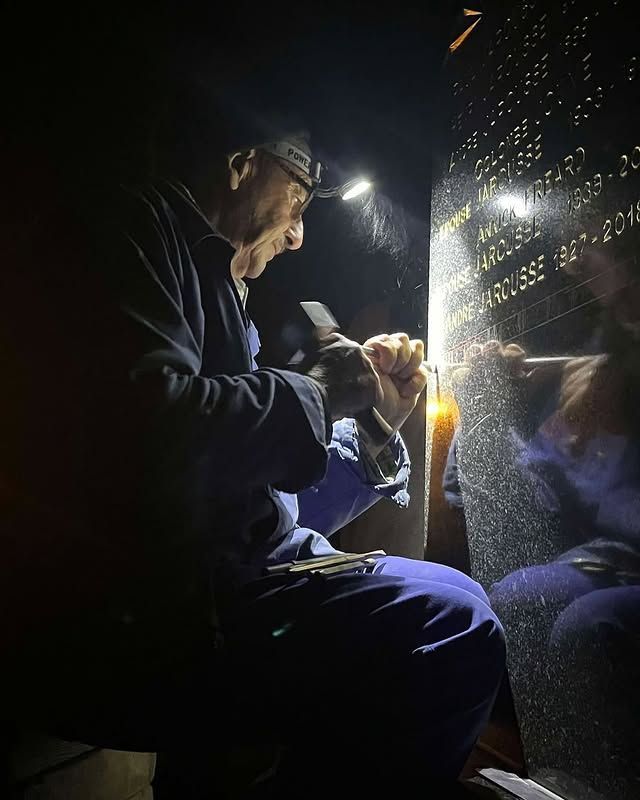 Une personne éclaire une plaque réfléchissante avec une lampe torche, il grave la plaque.