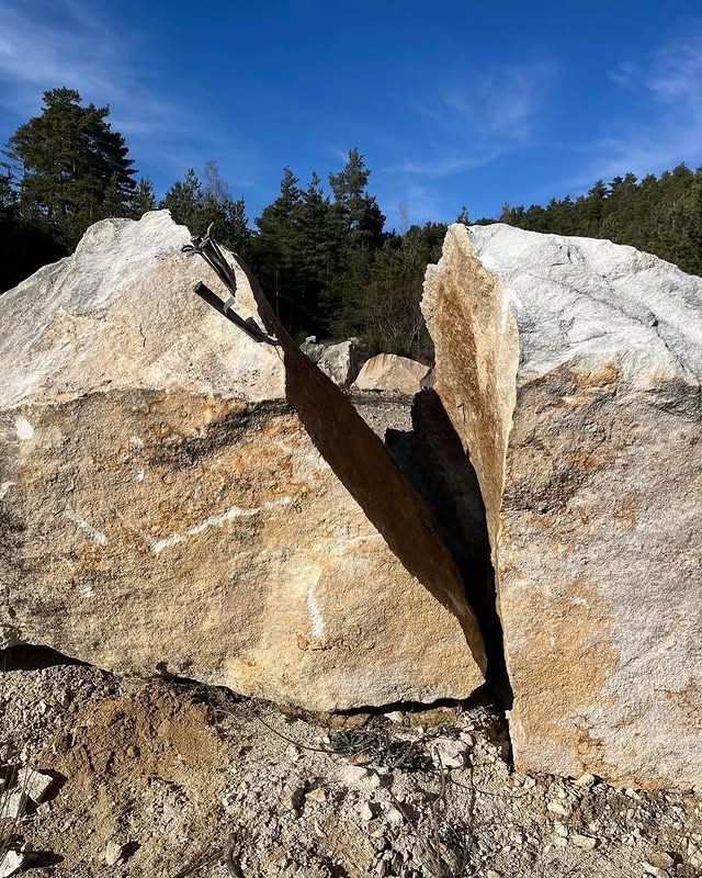 Gros blocs de pierre fendus dans une clairière ensoleillée sous un ciel bleu