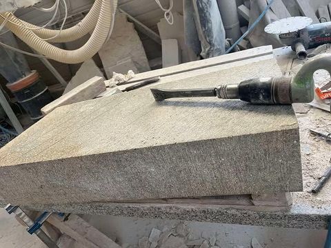 Découpe d'une dalle de comptoir en pierre à l'aide d'une scie électrique dans un atelier