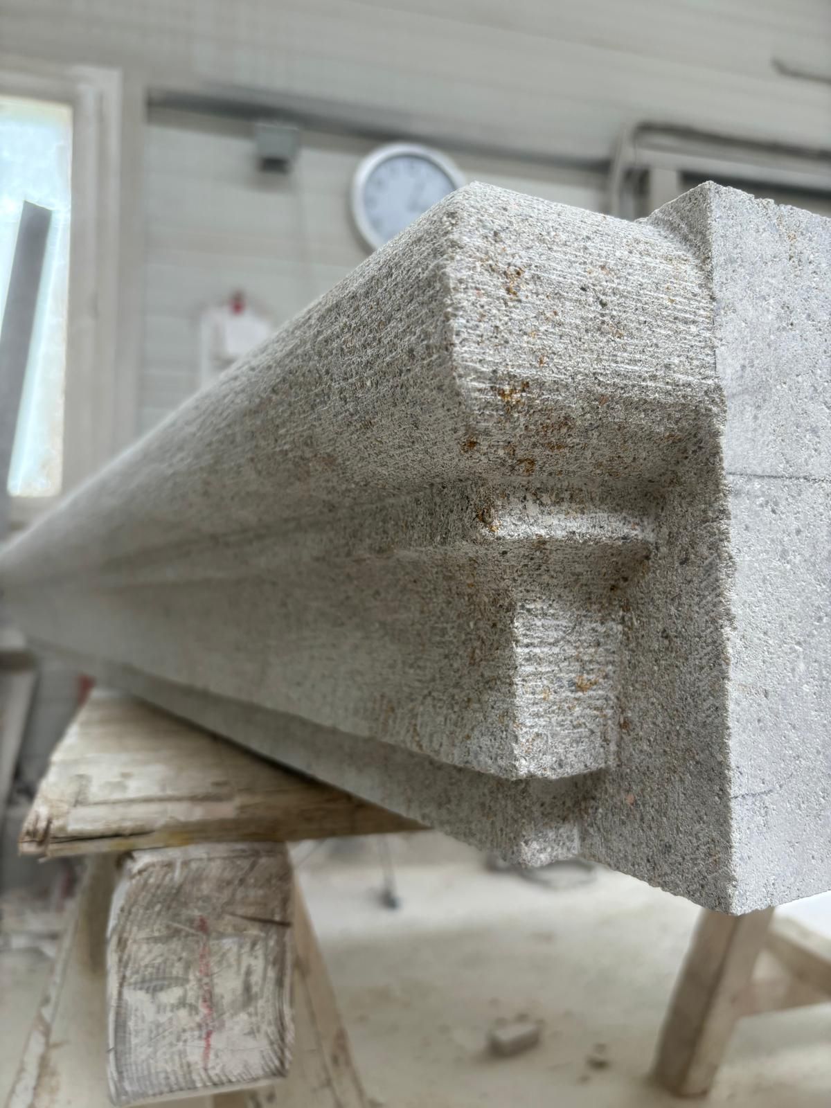 Gros plan sur une poutre en béton brut sur un établi dans un environnement de construction