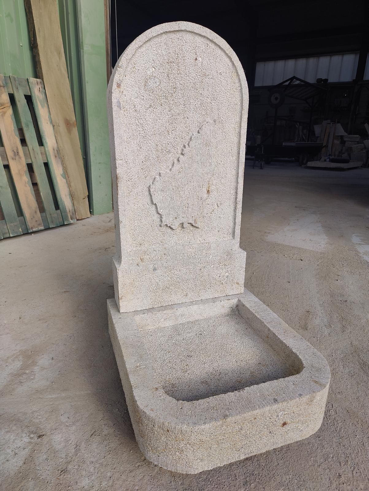 Fontaine à eau extérieure en béton pour animaux de compagnie, avec dossier et bassin, installée dans un atelier.