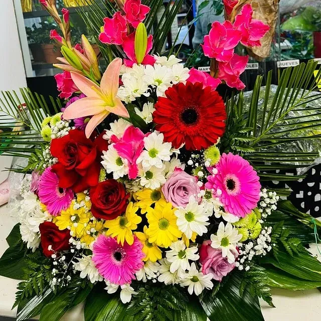 Un ramo de flores de colores está sobre una mesa.